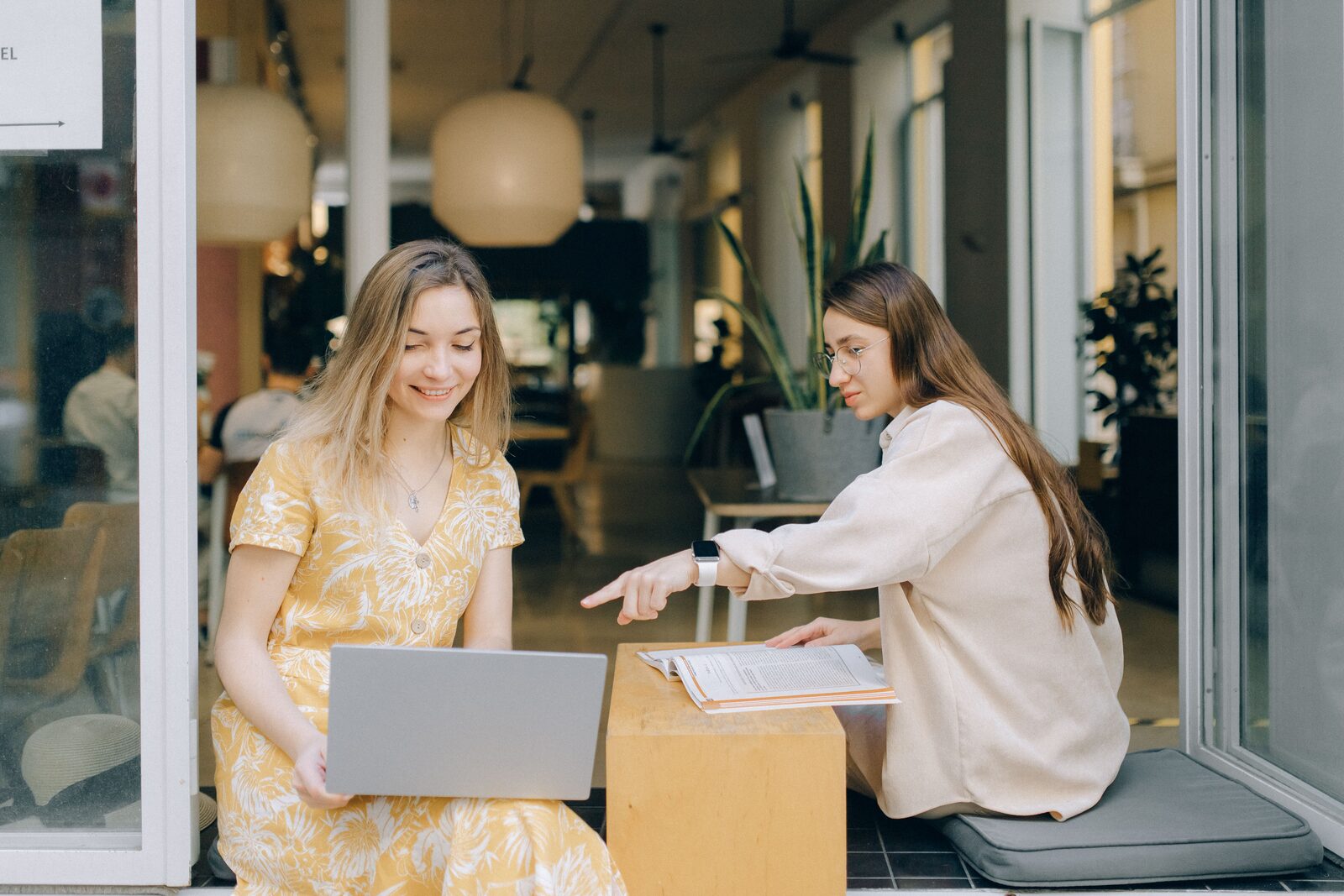 Twee jonge vrouwen bekijken samen cijfers op een laptop